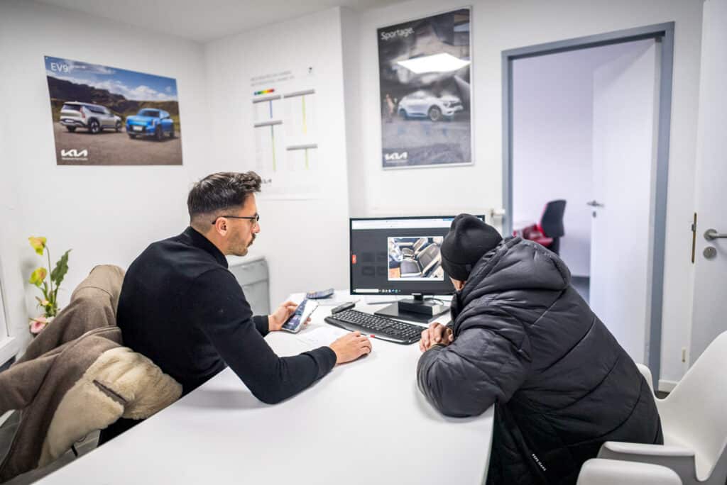 Vendeur du garage Incar Motor à Ans accompagnant un client dans la configuration de son véhicule dans un bureau dédié.