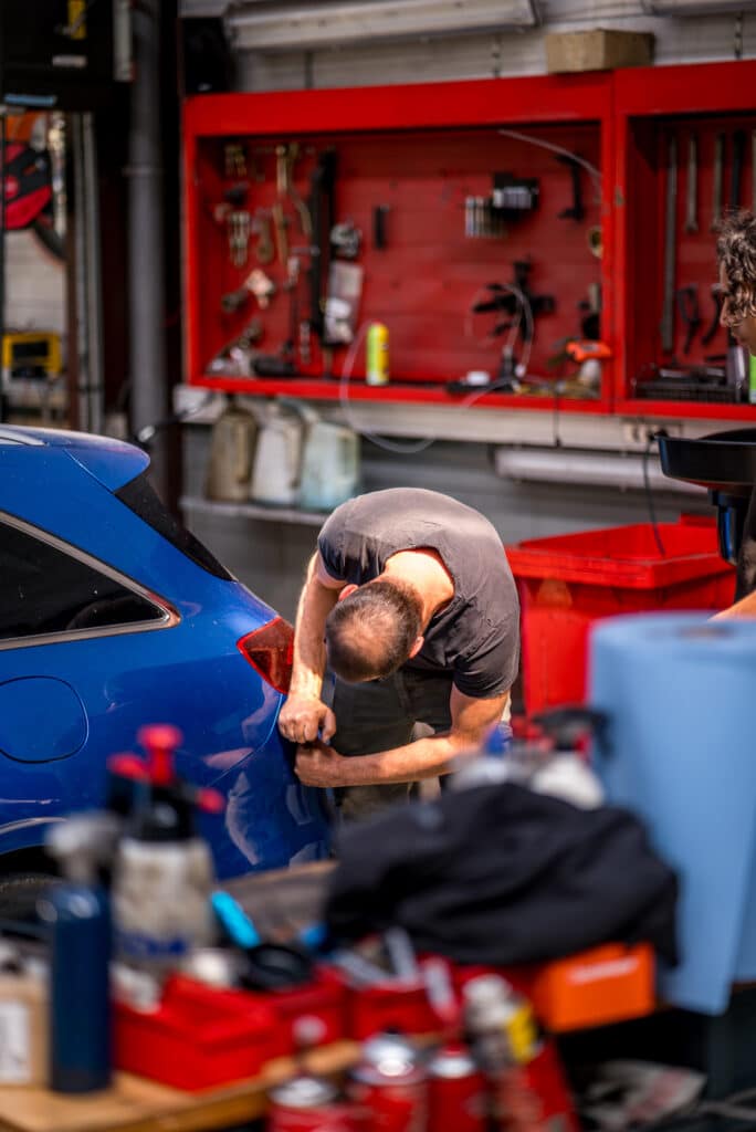 Technicien Incar Motor effectuant une révision moteur dans le garage de Houffalize