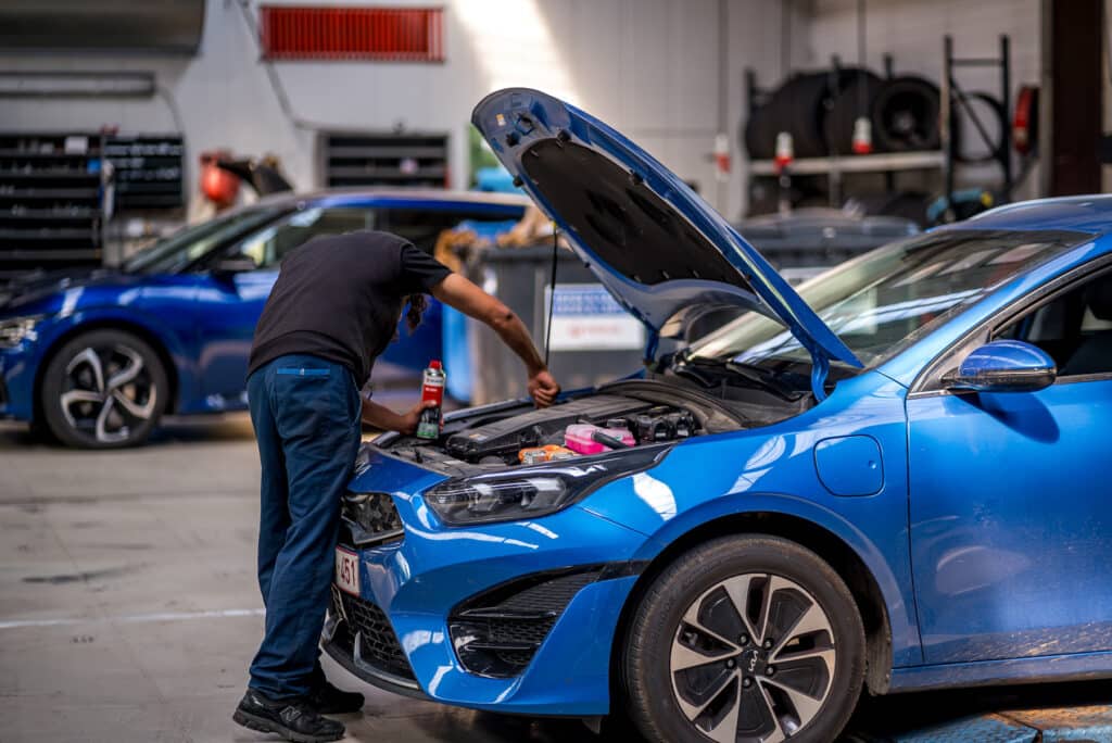 Technicien Incar Motor effectuant une révision moteur dans le garage de Houffalize