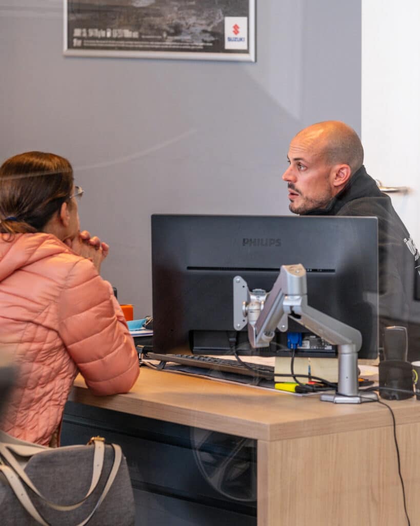 Employé administratif du garage Incar Motor à Arlon expliquant un devis à un client.